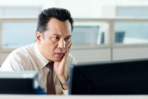 man with sleep apnea staring at computer screen needs sleep apnea treatment to improve work performance