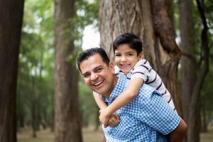 Man with child smiling because testosterone replacement therapy gave him energy and helped him achieve his New Year's goals