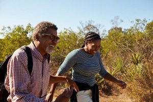 man and woman hiking to stay healthy as recommended by men's health clinic