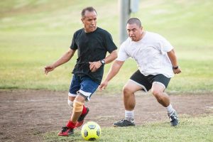 two men playing soccer after weight loss with TRT therapy