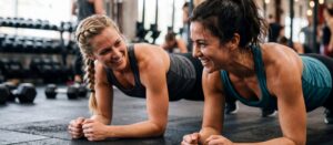 Two women planking, enjoying a workout.