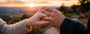 Man, and his wife holding hands with sunset in the background.