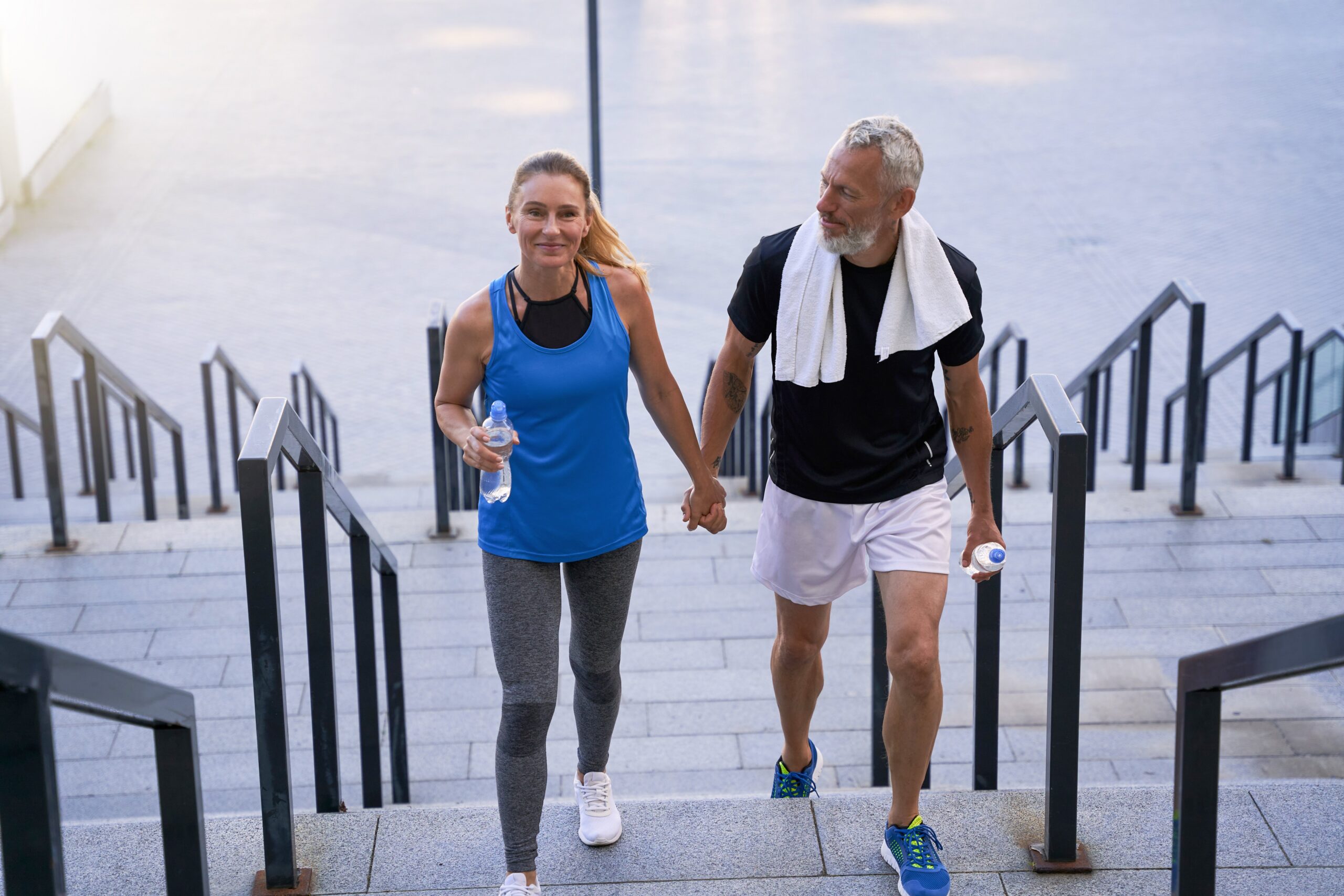 Active couple walking up outdoor steps — free B12 shot for new patients