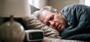 Man who suffers from sleep apnea and obesity sleeps in bed.