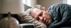 Man who suffers from sleep apnea and obesity sleeps in bed.